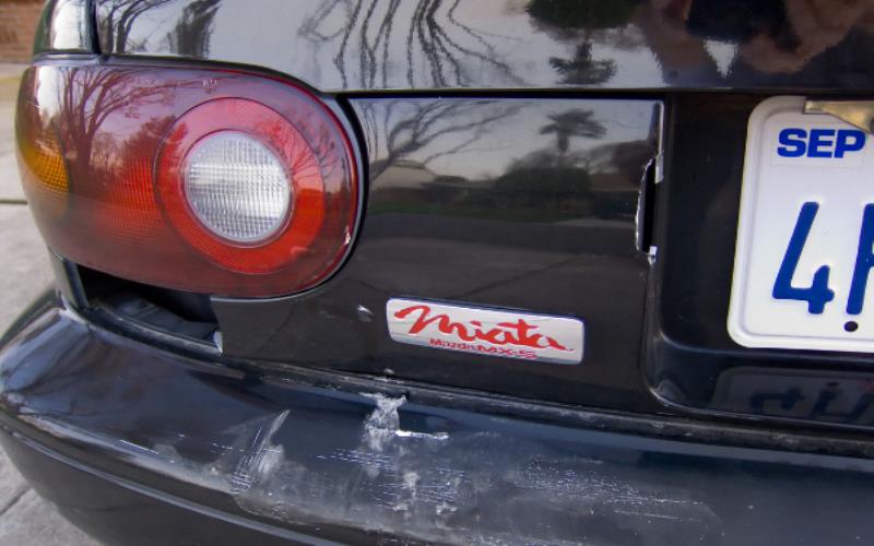 Broken tail light and scratched bumper.